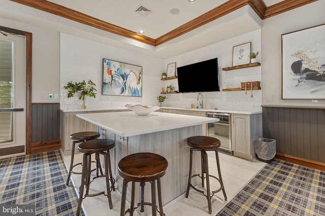 12921 Centre Park Cir Unit 102, Herndon, VA 20171 - kitchen with open shelves, a kitchen bar, light countertops, crown molding, and a center island