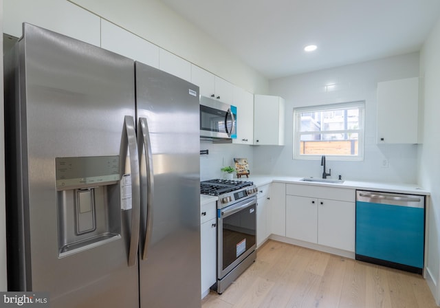 622 Mcclellan St, Philadelphia, PA 19148 - kitchen featuring appliances with stainless steel finishes, light wood finished floors, light countertops, white cabinetry, and recessed lighting