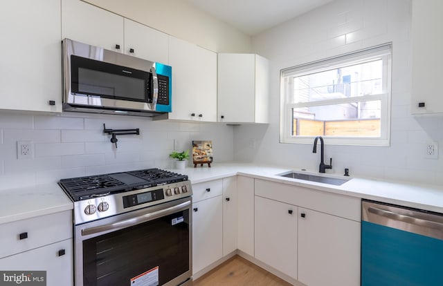 622 Mcclellan St, Philadelphia, PA 19148 - kitchen with stainless steel appliances, tasteful backsplash, and white cabinetry