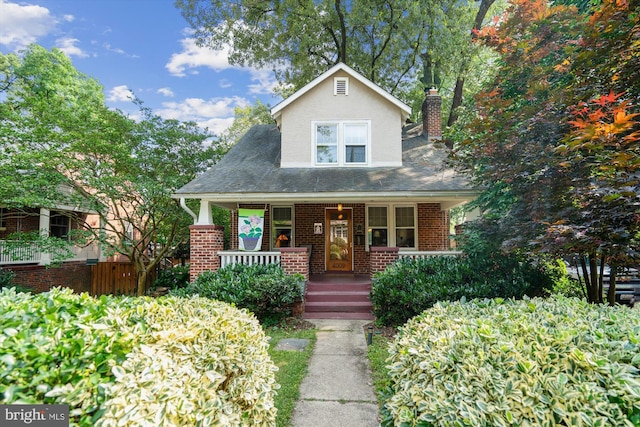 4009 Oglethorpe St, Hyattsville, MD 20782 - bungalow featuring a chimney, a porch, stucco siding, and brick siding
