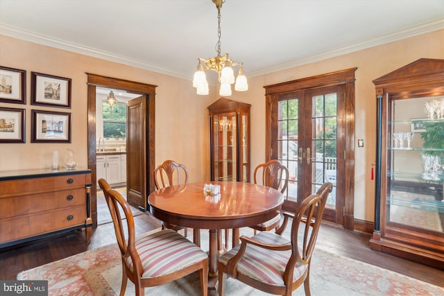 4009 Oglethorpe St, Hyattsville, MD 20782 - dining space featuring plenty of natural light, dark wood finished floors, a chandelier, crown molding, and french doors
