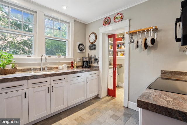 4009 Oglethorpe St, Hyattsville, MD 20782 - kitchen with white cabinetry, ornamental molding, and black microwave