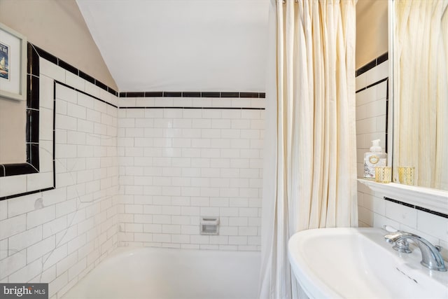 4009 Oglethorpe St, Hyattsville, MD 20782 - bathroom featuring vaulted ceiling, shower / bath combo with shower curtain, and tile walls