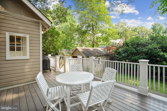 4009 Oglethorpe St, Hyattsville, MD 20782 - wooden terrace featuring grilling area, view of scattered trees, a storage unit, and outdoor dining area