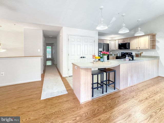 215 Westlake Blvd, Prince Frederick, MD 20678 - kitchen featuring black appliances, light wood-style flooring, light countertops, open shelves, and a peninsula