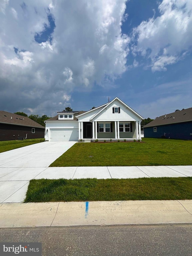 36821 W Old Gate Dr, Georgetown, DE 19947 - view of front of property with concrete driveway, a garage, a front yard, and covered porch