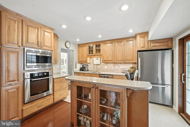 8823 Newport Ct, Springfield, VA 22153 - kitchen featuring stainless steel appliances, glass insert cabinets, decorative backsplash, a center island, and recessed lighting