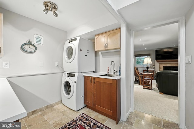 8823 Newport Ct, Springfield, VA 22153 - laundry area with estacked washer and dryer, cabinet space, a tile fireplace, recessed lighting, and light stone finish floors