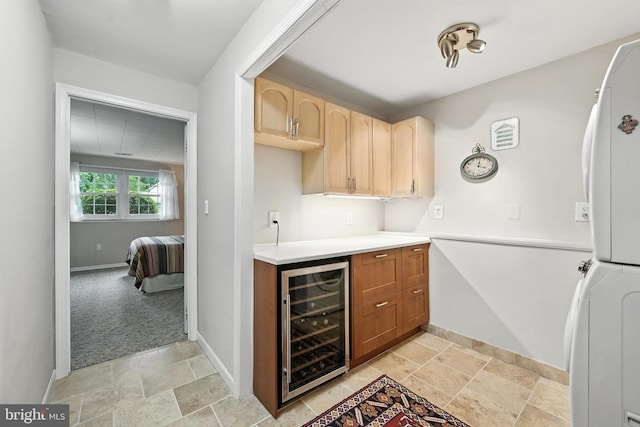 8823 Newport Ct, Springfield, VA 22153 - bar area with wine cooler, stacked washer and clothes dryer, light stone finish flooring, and fridge