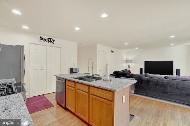 1765 Ivy Pump Ln, York, PA 17408 - kitchen with stainless steel appliances, light wood finished floors, light stone countertops, a center island with sink, and recessed lighting