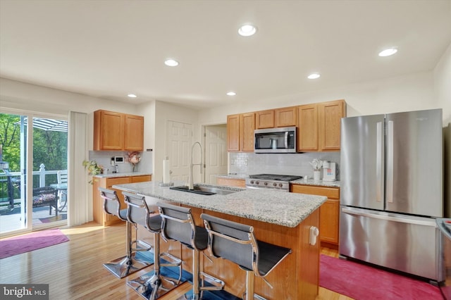 1765 Ivy Pump Ln, York, PA 17408 - kitchen with appliances with stainless steel finishes, tasteful backsplash, a breakfast bar, light wood finished floors, and recessed lighting