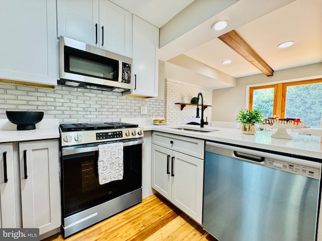 5933 Westridge Ct, Alexandria, VA 22310 - kitchen featuring appliances with stainless steel finishes, light countertops, tasteful backsplash, beam ceiling, and light wood finished floors