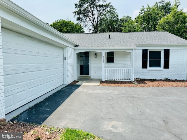 5933 Westridge Ct, Alexandria, VA 22310 - view of front of property with covered porch, brick siding, asphalt driveway, a garage, and roof with shingles