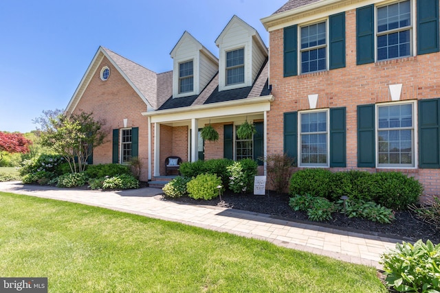 872 The Old Station Ct, Woodbine, MD 21797 - view of front of home with brick siding, a front yard, roof with shingles, and a porch