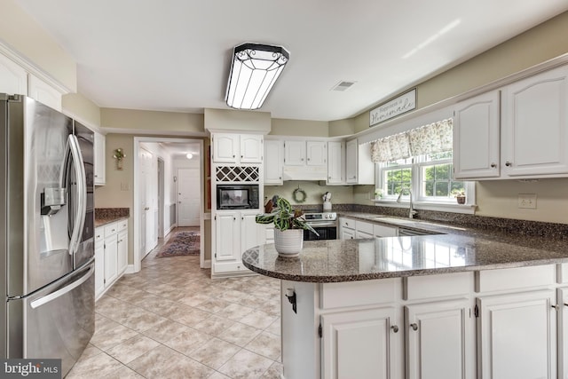 872 The Old Station Ct, Woodbine, MD 21797 - kitchen with stainless steel fridge, black microwave, a peninsula, oven, and under cabinet range hood