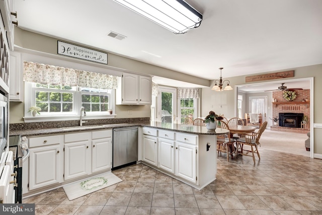 872 The Old Station Ct, Woodbine, MD 21797 - kitchen featuring stainless steel dishwasher, white cabinetry, a peninsula, and a fireplace
