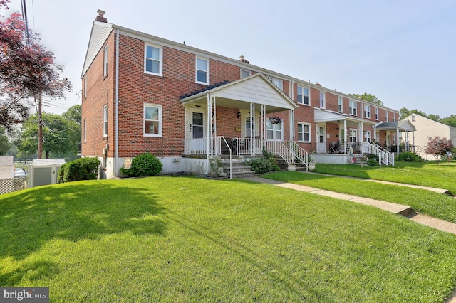 159 Garden Ridge Rd, Catonsville, MD 21228 - townhome / multi-family property featuring a porch, brick siding, a front yard, and a chimney