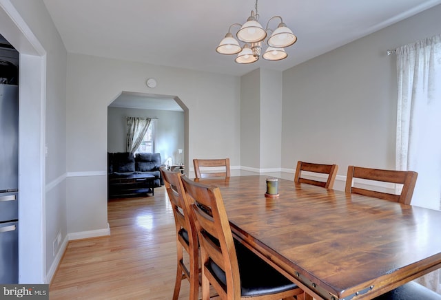159 Garden Ridge Rd, Catonsville, MD 21228 - dining space featuring arched walkways, light wood finished floors, and a chandelier