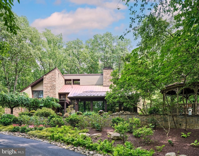 7028 Ely Rd, New Hope, PA 18938 - mid-century home with a standing seam roof, a chimney, a metal roof, and stone siding