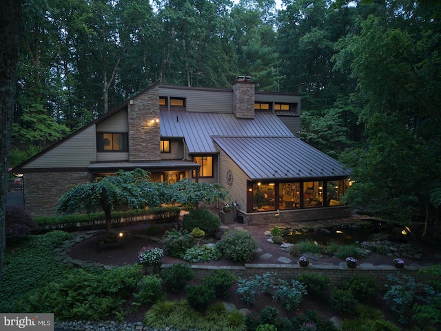 7028 Ely Rd, New Hope, PA 18938 - rear view of house with a standing seam roof, a chimney, stone siding, and a metal roof