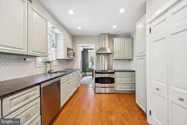 257 Merion Ave, Haddonfield, NJ 08033 - kitchen featuring appliances with stainless steel finishes, wall chimney exhaust hood, light wood finished floors, decorative backsplash, and recessed lighting