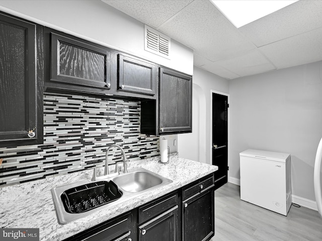 332 W Maple St, York, PA 17401 - kitchen featuring refrigerator, decorative backsplash, a drop ceiling, light countertops, and light wood-style flooring