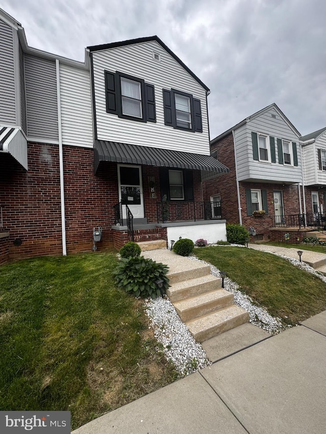 332 W Maple St, York, PA 17401 - view of front of house featuring covered porch, brick siding, and a front lawn