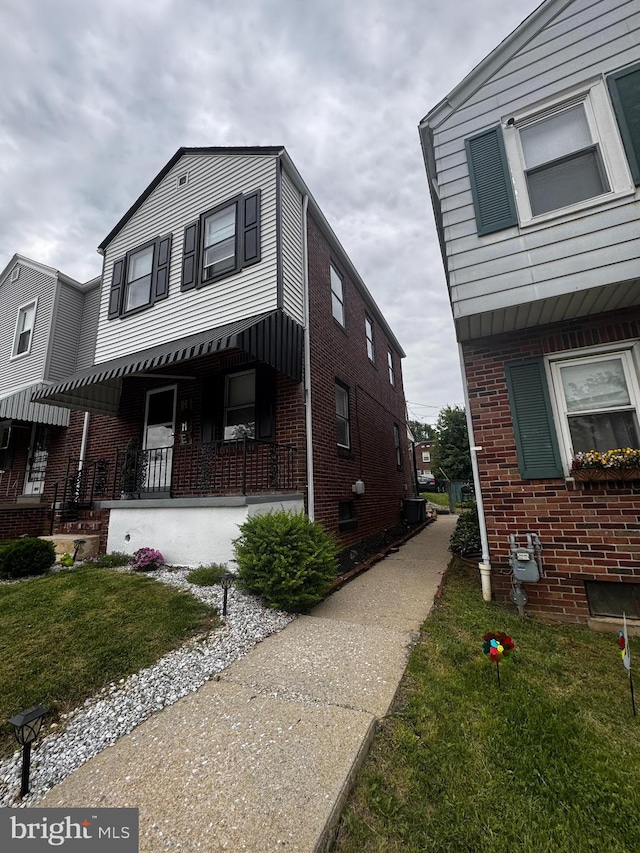 332 W Maple St, York, PA 17401 - view of home's exterior with brick siding, a yard, and a porch