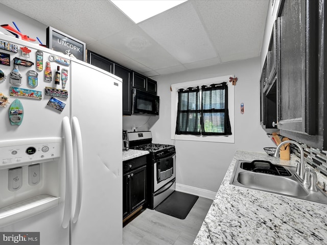 332 W Maple St, York, PA 17401 - kitchen with white refrigerator with ice dispenser, stainless steel range with gas stovetop, black microwave, dark cabinets, and light countertops