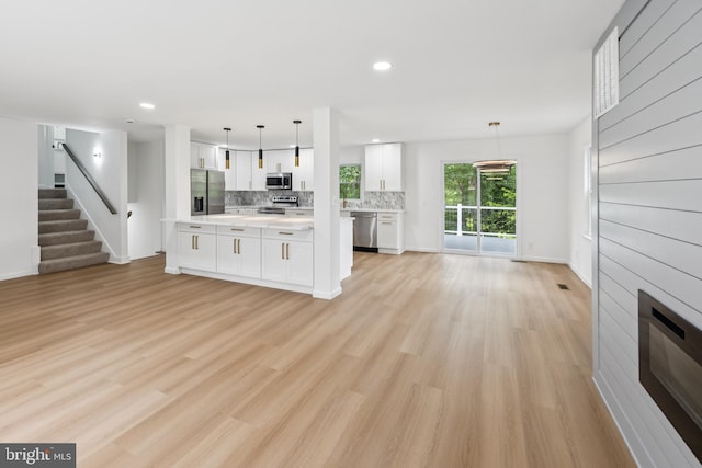 6612 Jacks Ct, Mount Airy, MD 21771 - unfurnished living room with stairs, light wood finished floors, recessed lighting, a fireplace, and heating unit