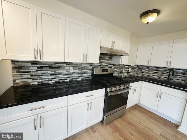 7269 Rutland St, Philadelphia, PA 19149 - kitchen featuring stainless steel gas range oven, under cabinet range hood, dark countertops, and backsplash