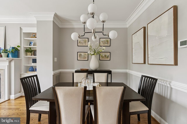 1206 N Pitt St, Alexandria, VA 22314 - dining area with crown molding, a chandelier, wood finished floors, and built in shelves