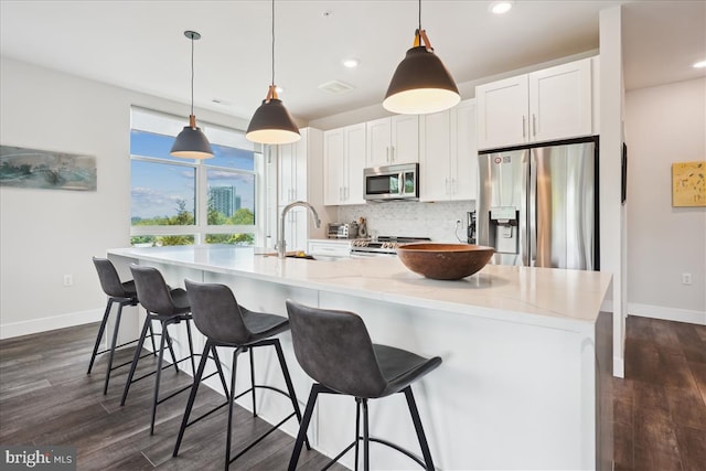 1761 Old Meadow Rd Unit 412, Mclean, VA 22102 - kitchen featuring appliances with stainless steel finishes, dark wood-style flooring, white cabinets, tasteful backsplash, and a large island