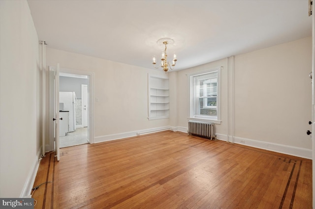 445 Dupont St, Philadelphia, PA 19128 - unfurnished room featuring radiator, a chandelier, built in shelves, and light wood-type flooring