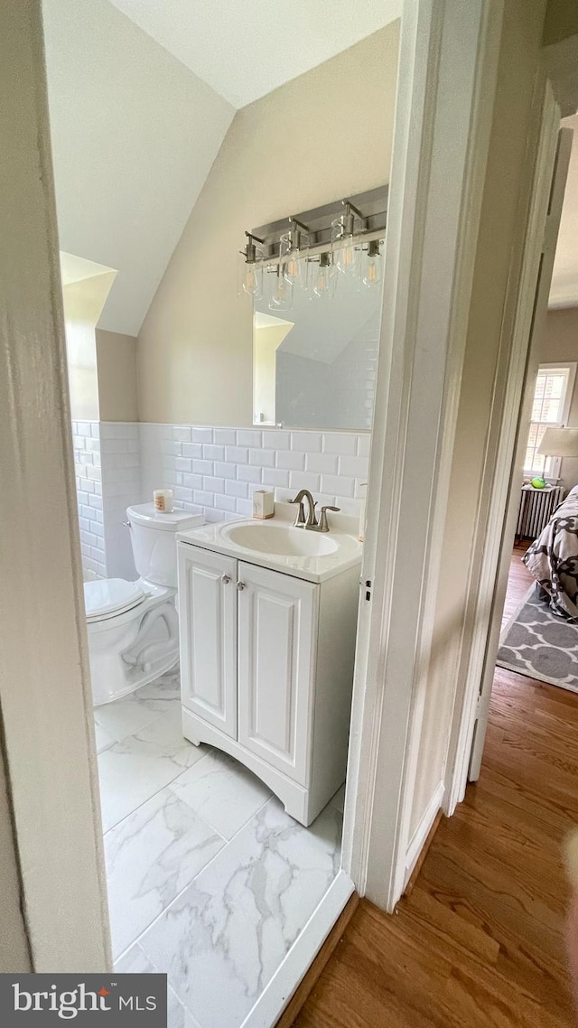 4420 Brandywine St NW, Washington, DC 20016 - bathroom featuring vanity, lofted ceiling, and tile walls