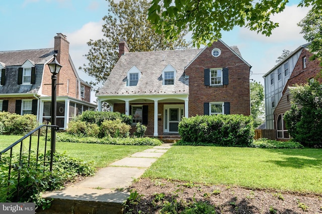 4420 Brandywine St NW, Washington, DC 20016 - cape cod-style house featuring brick siding, covered porch, a front yard, and a chimney