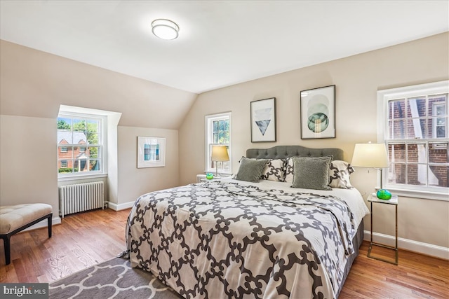 4420 Brandywine St NW, Washington, DC 20016 - bedroom featuring radiator, multiple windows, vaulted ceiling, and wood finished floors