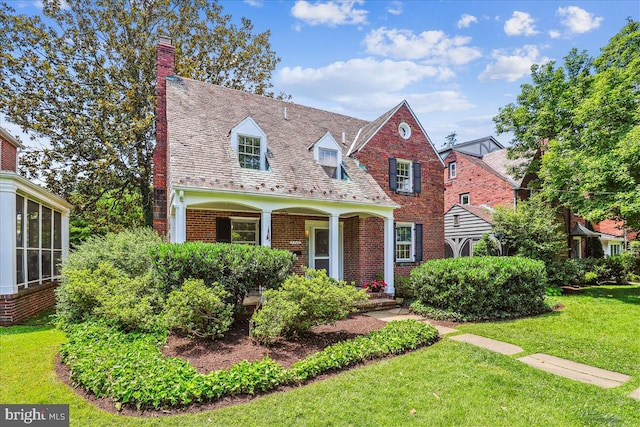 4420 Brandywine St NW, Washington, DC 20016 - new england style home featuring brick siding, a front yard, a chimney, a porch, and a high end roof