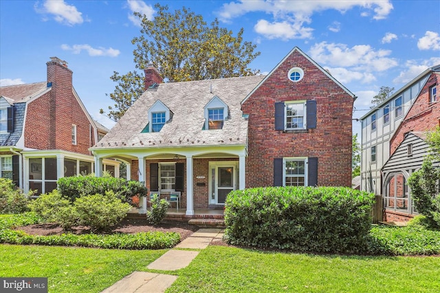 4420 Brandywine St NW, Washington, DC 20016 - view of front of home with a porch, brick siding, a front yard, and a chimney