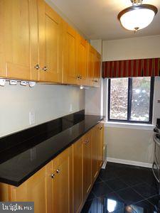 3901 Tunlaw Rd NW Unit 202, Washington, DC 20007 - kitchen featuring dark countertops and dark tile patterned flooring