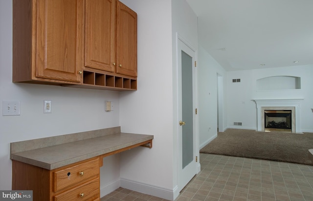 2125 Chatham Way, Harrisburg, PA 17110 - kitchen with built in desk, a glass covered fireplace, open floor plan, light carpet, and open shelves