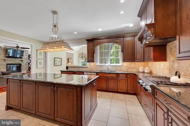 650 S Warren Ave, Malvern, PA 19355 - kitchen with stainless steel gas cooktop, backsplash, ceiling fan, a fireplace, and a center island