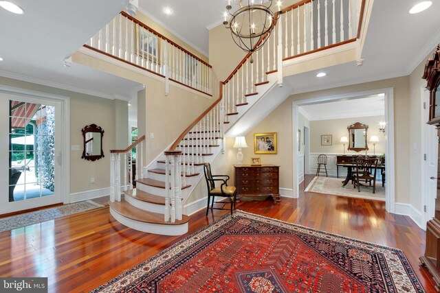 650 S Warren Ave, Malvern, PA 19355 - foyer entrance featuring wood-type flooring, stairs, a chandelier, crown molding, and a towering ceiling