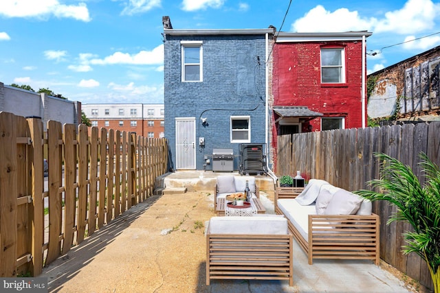 19 N Smallwood St, Baltimore, MD 21223 - rear view of house with an outdoor hangout area, a fenced backyard, a patio, and brick siding