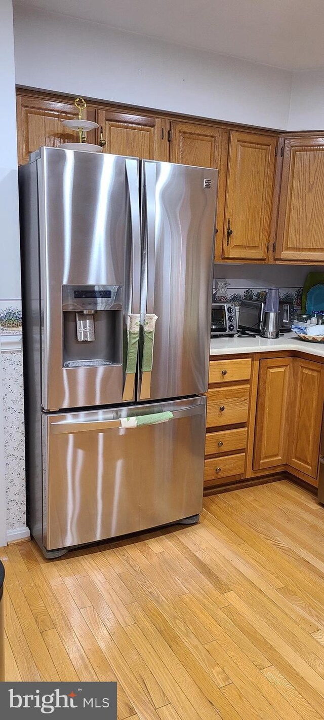 13209 Marthas Choice Cir, Bowie, MD 20720 - kitchen with stainless steel refrigerator with ice dispenser, light countertops, light wood-style flooring, and brown cabinets