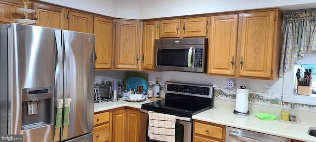 13209 Marthas Choice Cir, Bowie, MD 20720 - kitchen featuring appliances with stainless steel finishes, light countertops, and brown cabinetry