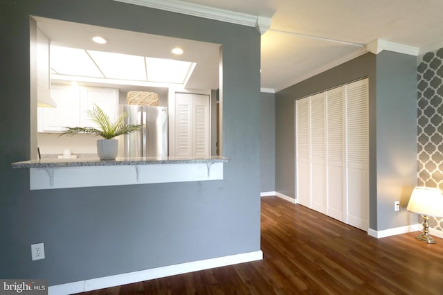 804 Stratford Dr Unit 11, State College, PA 16801 - kitchen with freestanding refrigerator, ornamental molding, a breakfast bar area, dark wood-style floors, and white cabinetry