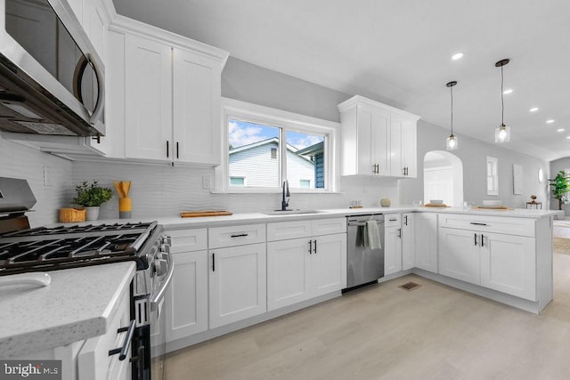 8247 River Rd, Pennsauken, NJ 08110 - kitchen featuring appliances with stainless steel finishes, light wood finished floors, white cabinetry, a peninsula, and recessed lighting