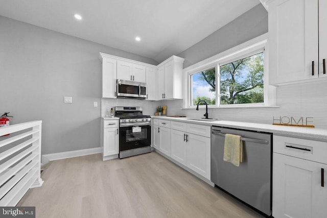 8247 River Rd, Pennsauken, NJ 08110 - kitchen with stainless steel appliances, light wood-style flooring, tasteful backsplash, white cabinets, and recessed lighting