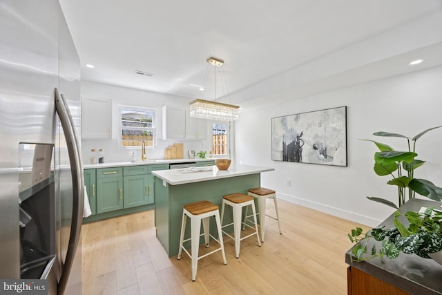 1232 S Bucknell St, Philadelphia, PA 19146 - kitchen with stainless steel appliances, green cabinets, light wood finished floors, a breakfast bar, and recessed lighting